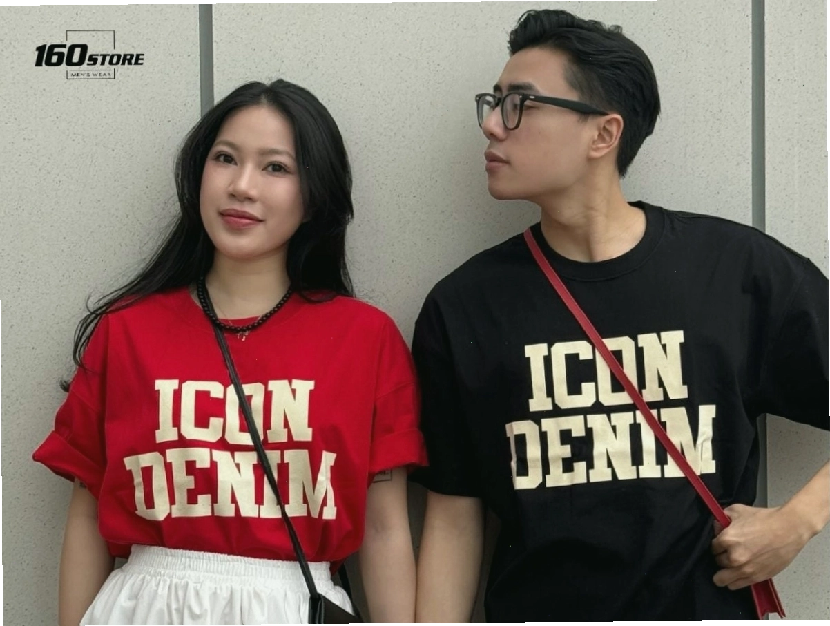 Cặp đôi mặc áo thun đôi in chữ đơn giản, quần jeans, tạo dáng tự nhiên khi đi dạo phố