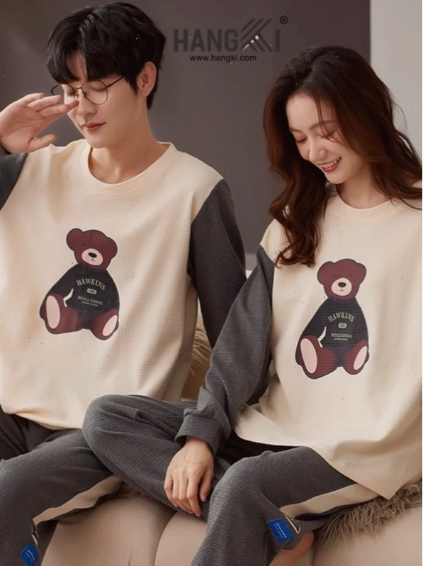 Cặp đôi mặc đồ ngủ đôi, cùng nhau đọc sách trên giường