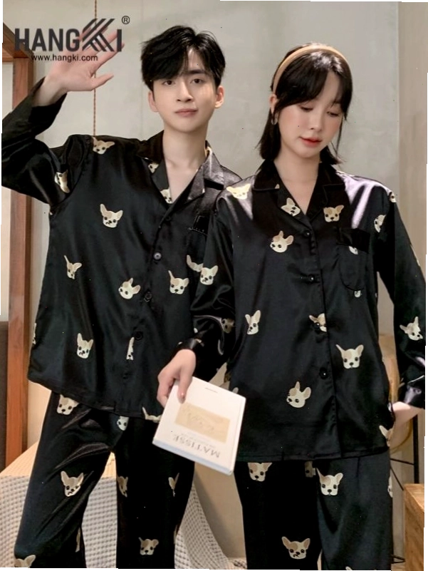 Cặp đôi mặc đồ pijama đôi kẻ sọc, cùng ngồi trên sofa đọc sách và trò chuyện vui vẻ