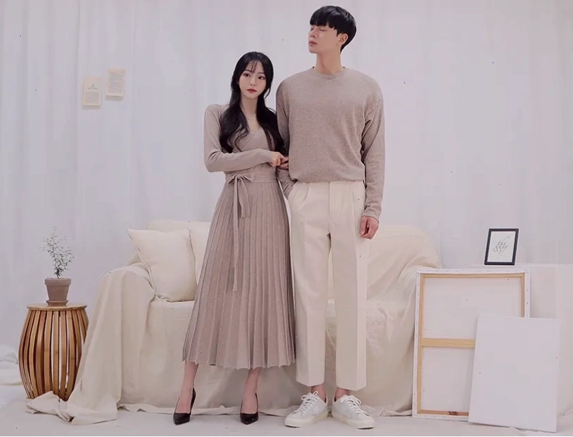 Cặp đôi tạo dáng từ phía sau, nắm tay nhau đi bộ trên bãi biển lúc hoàng hôn