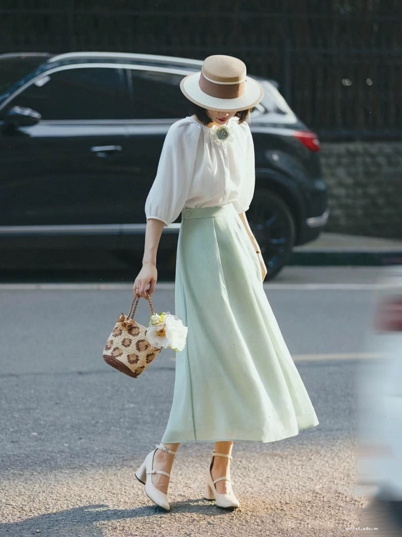 Chân váy dài vintage dáng xòe màu vàng đất, cạp cao, phối cùng áo kiểu tay ngắn màu trắng và sandal quai mảnh