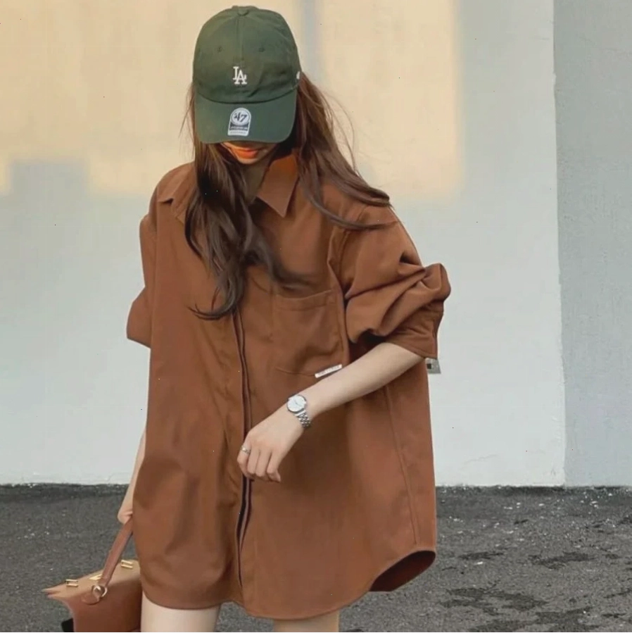 Cô gái diện áo sơ mi oversize, chân váy chữ A và túi xách nhỏ nhắn