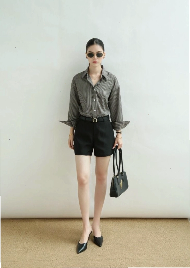 Cô gái diện áo sơ mi oversize họa tiết phối cùng quần jean ống rộng và túi kẹp nách