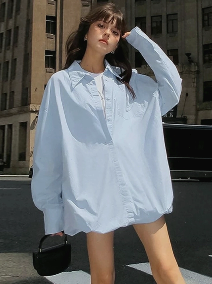 Cô gái diện áo sơ mi oversize màu trắng phối cùng quần jean ống rộng