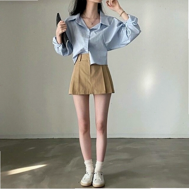 Cô gái diện áo sơ mi oversize trắng, quần short đen và phụ kiện túi xách