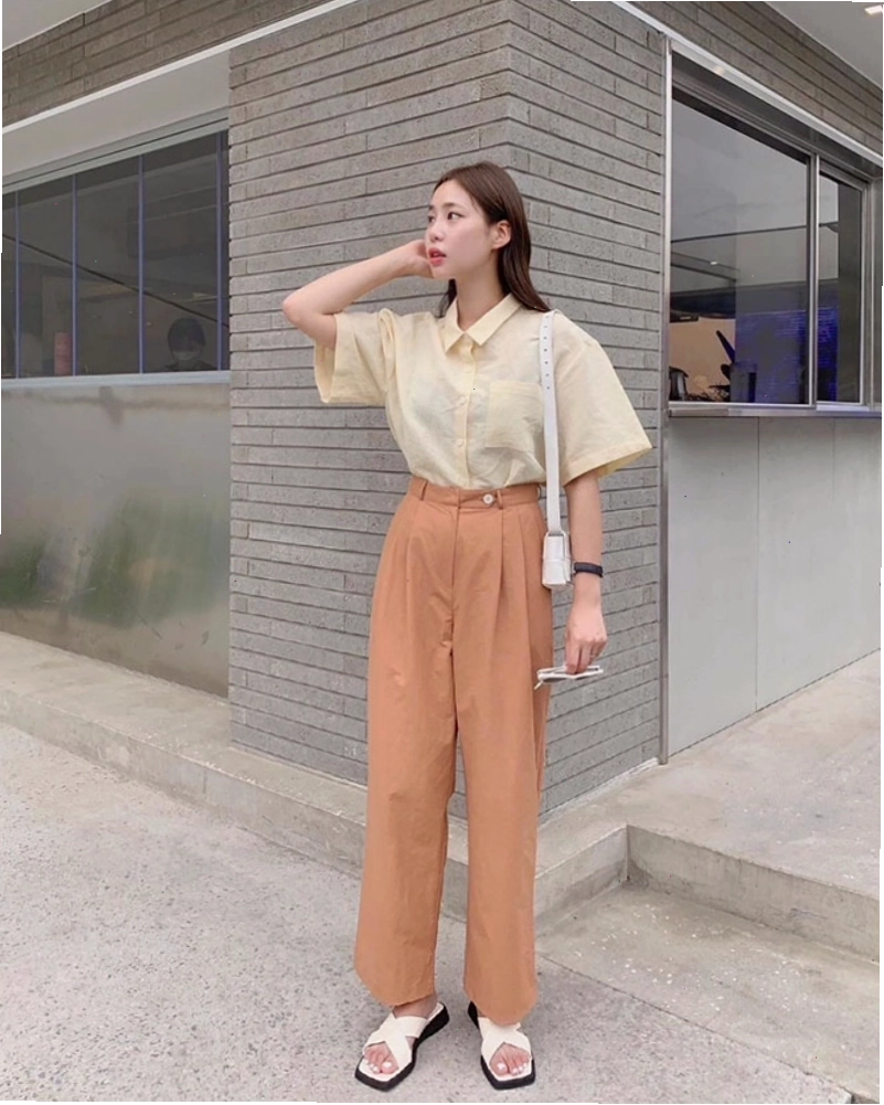 Cô gái diện áo sơ mi tay ngắn phối cùng quần short và túi kẹp nách