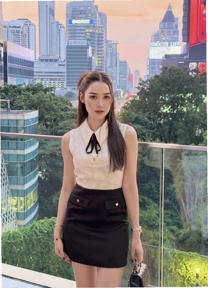 Cô gái diện chân váy chữ A dáng ngắn màu xanh dương phối áo ba lỗ trắng và phụ kiện dây chuyền