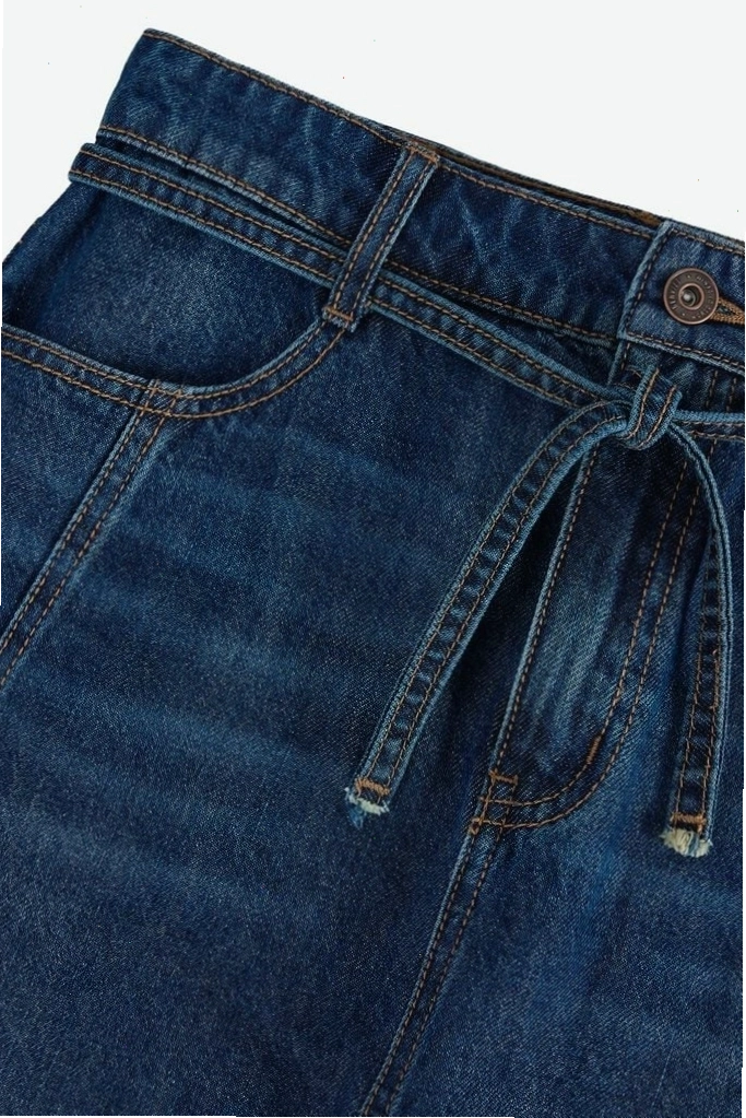 Cô gái diện chân váy jean ngắn với áo thun và phụ kiện túi xách mini