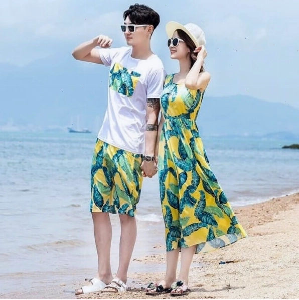 Cô gái diện đầm maxi quyến rũ, chàng trai diện áo sơ mi, cả hai tay trong tay trên bãi biển