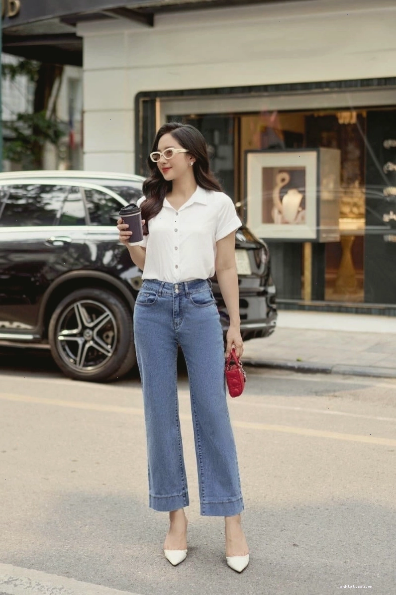 Cô gái diện quần jean ống suông màu xanh bạc với áo ba lỗ trắng và giày thể thao