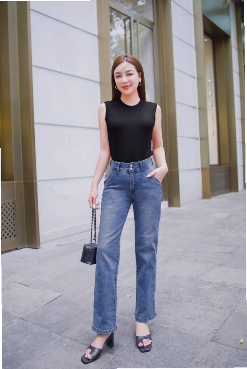 Cô gái diện quần jean ống suông màu xanh bạc với áo sơ mi trắng oversize và giày sneaker