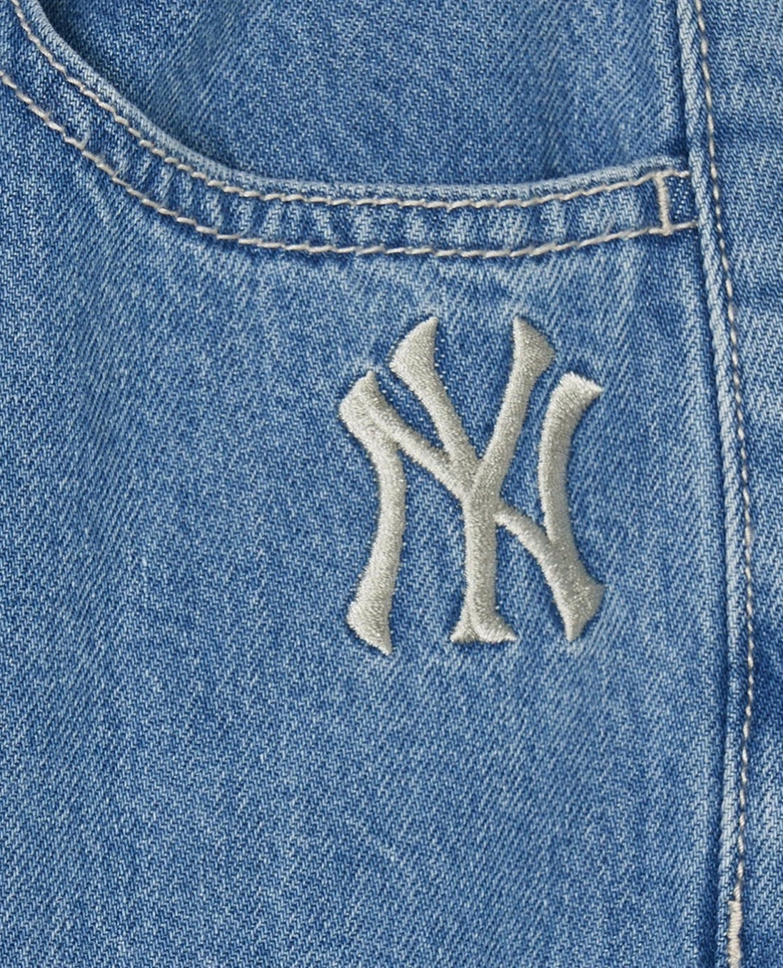 Cô gái diện quần jeans nữ ống rộng cạp cao, phối cùng áo hai dây và giày sneakers trắng