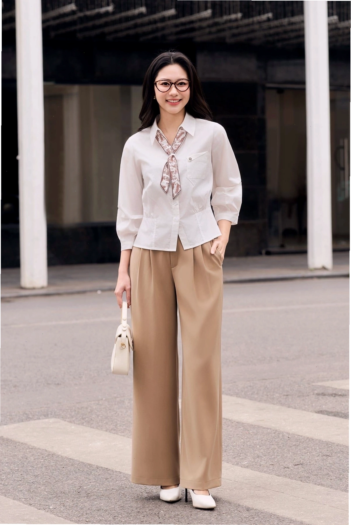 Cô gái diện quần vải ống rộng màu đen, có ly phía trước, phối cùng áo hai dây và blazer