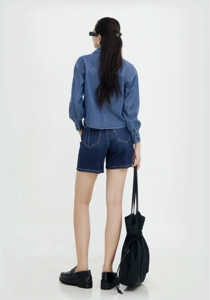 Cô gái mặc áo sơ mi denim nữ dáng crop, phối cùng chân váy đen