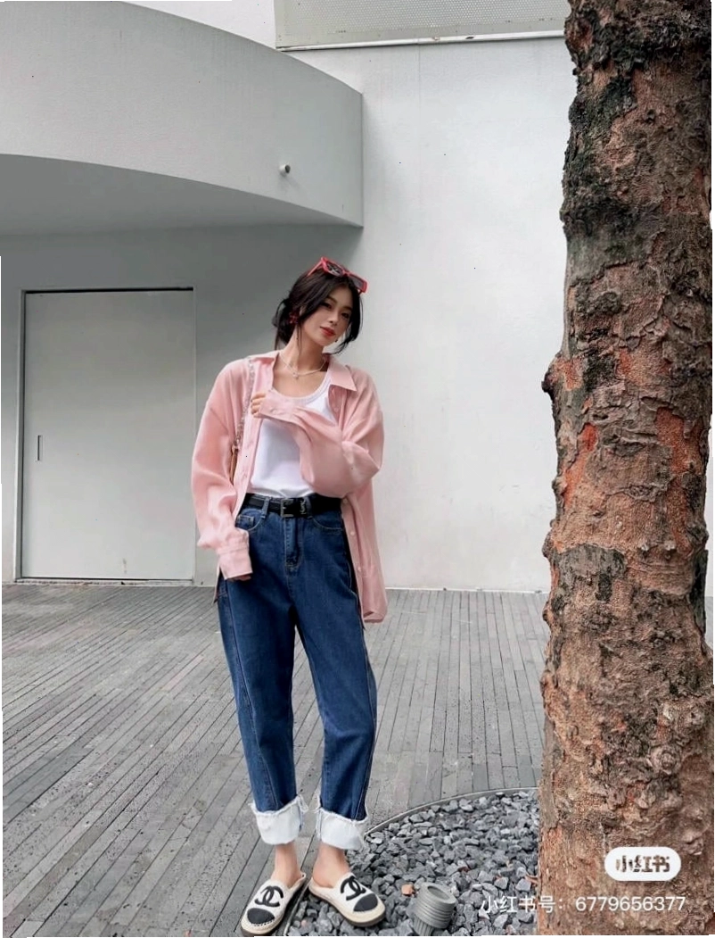 Cô gái mặc áo sơ mi khoác ngoài kẻ sọc, phối cùng áo thun và quần short