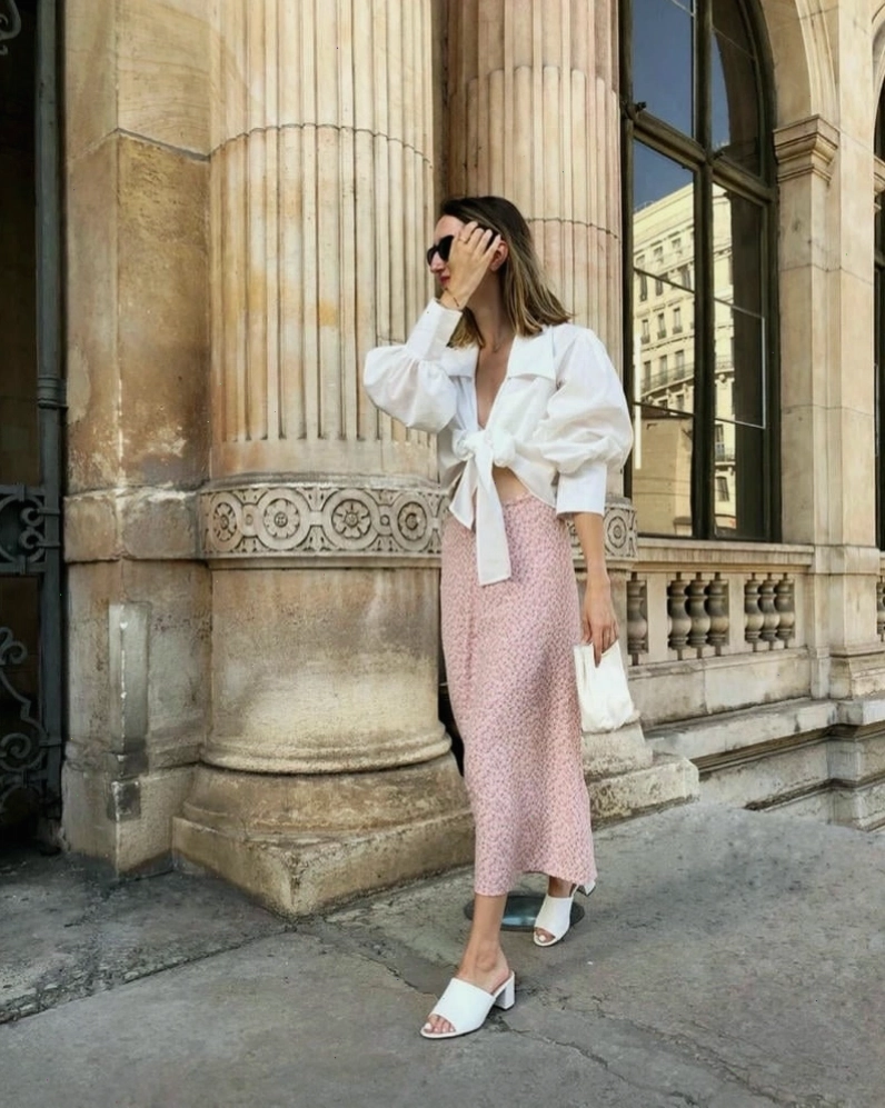 Cô gái mặc chân váy dài vintage kẻ caro nâu, cạp cao, dáng chữ A, phối cùng áo sơ mi trắng tay phồng và giày Mary Jane