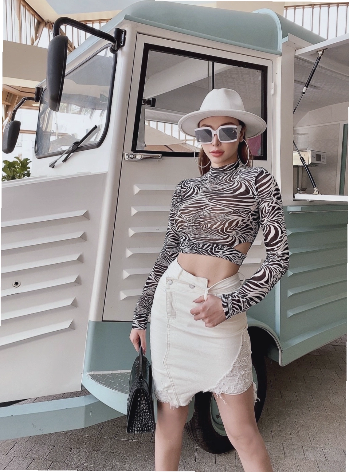 Cô gái mặc chân váy jean rách ngắn kết hợp áo thun graphic tee và sneakers