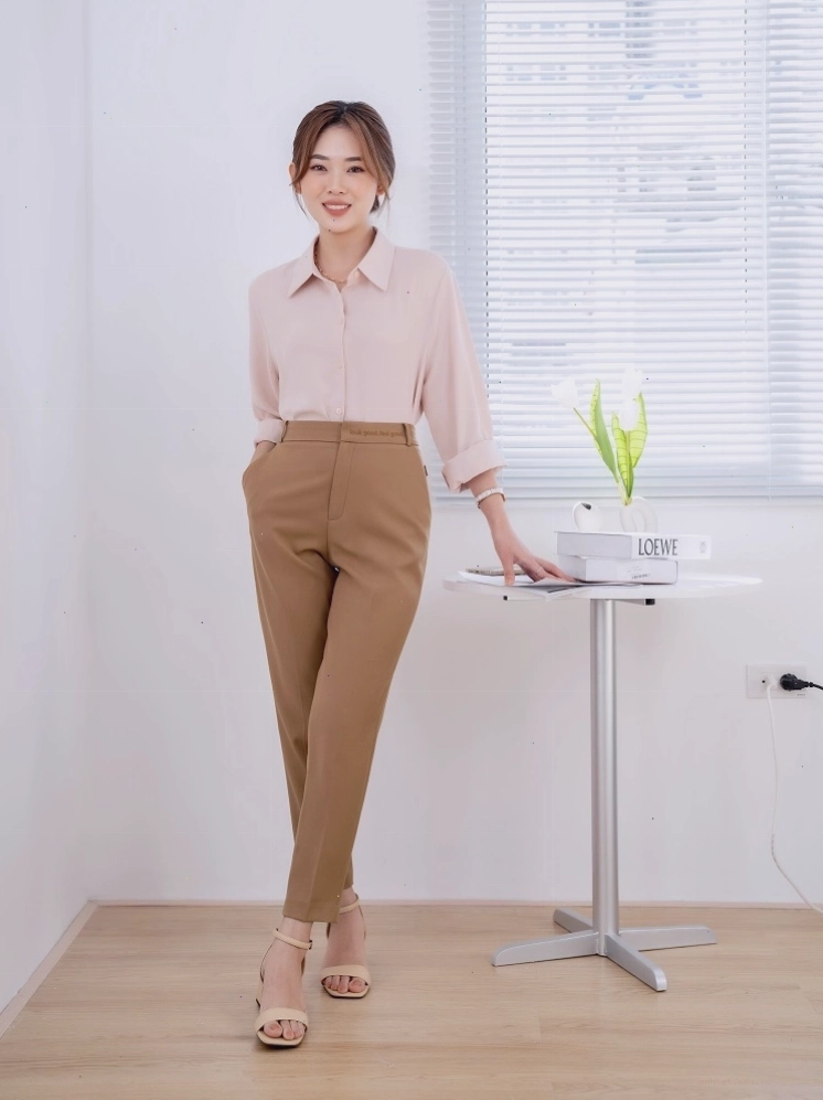 Cô gái mặc quần âu lưng cao ống rộng màu be phối cùng sơ mi kiểu và giày cao gót