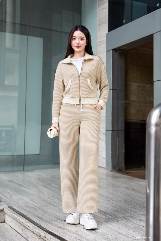 Cô gái mặc quần dài dáng suông màu xám, áo hoodie cùng tông và mũ len