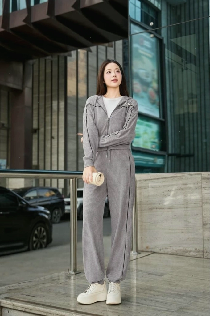 Cô gái mặc quần dài nỉ cừu bo gấu màu nâu, áo sweater và giày bốt