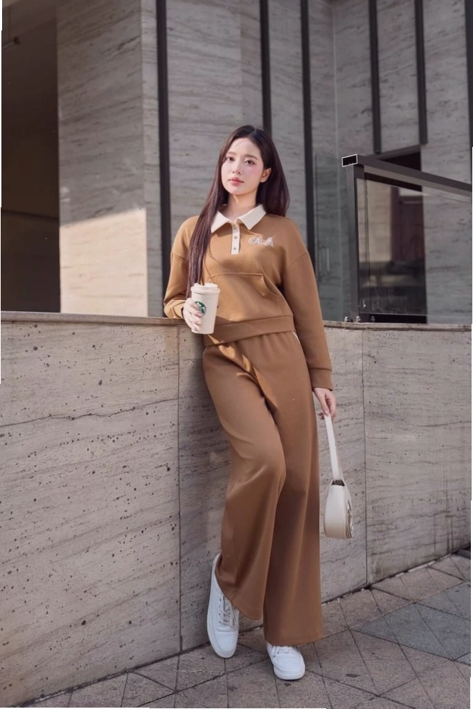 Cô gái mặc quần dài nữ chất Umi dáng suông màu đen, áo croptop trắng và giày thể thao