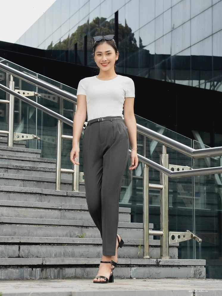 Cô gái mặc quần tây lưng cao màu đen phối cùng áo sơ mi trắng và giày búp bê