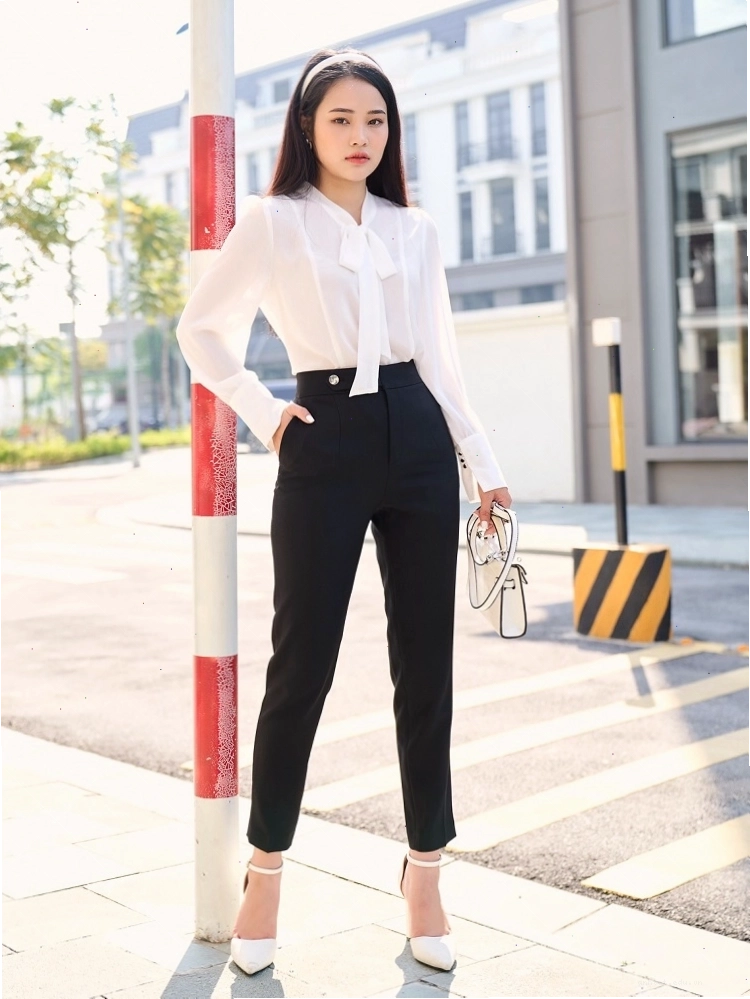 Cô gái mặc quần tây lưng cao ống nhỏ màu đen phối cùng áo kiểu và giày cao gót