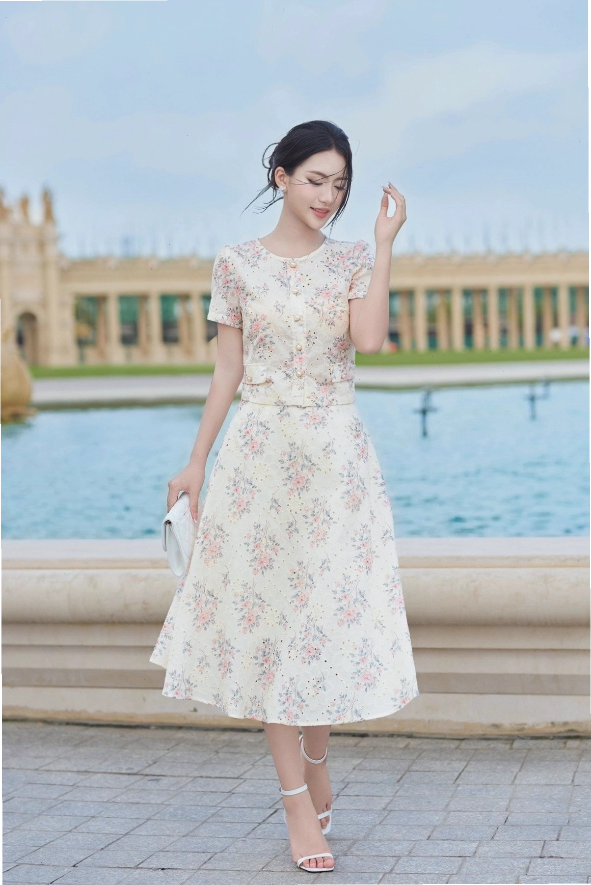 Cô gái mặc set áo croptop ngắn tay màu hồng phấn phối cùng chân váy xòe trắng dáng dài