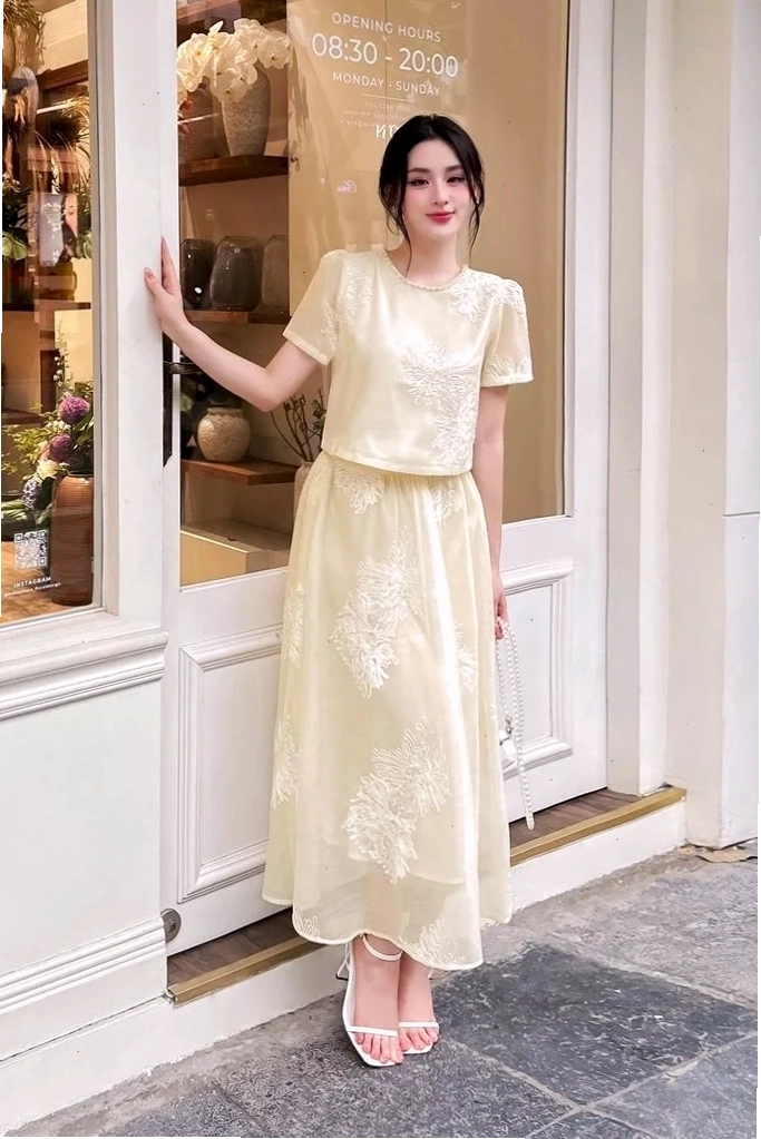 Cô gái mặc set áo croptop ôm sát màu đen phối cùng chân váy chữ a kẻ caro đen trắng