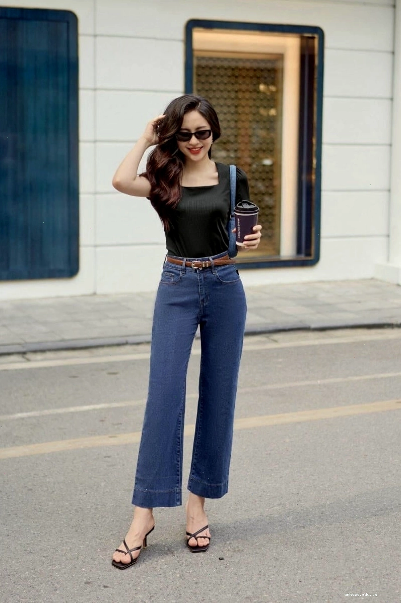 Cô gái phối quần jean ống suông với áo len mỏng màu nâu và giày loafer