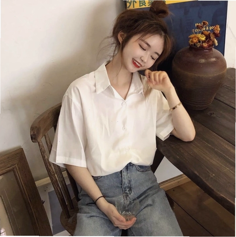 Cô gái trẻ trung diện áo sơ mi trắng tay ngắn form rộng phối cùng quần jeans ống loe