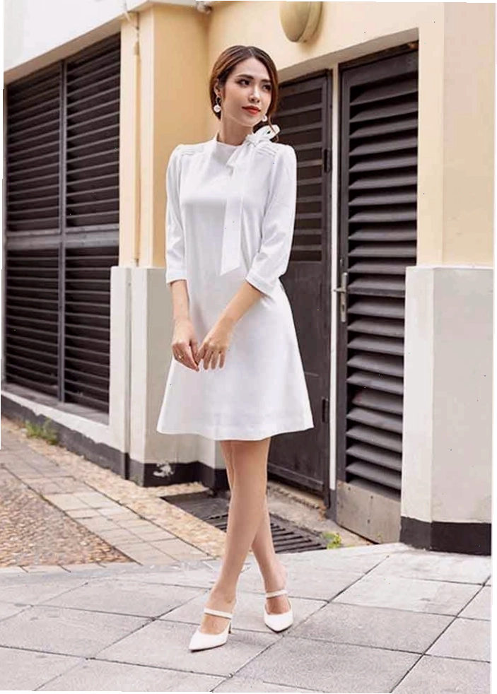 Đầm dáng suông màu trắng tinh khôi, cổ tròn, tay ngắn, mang phong cách năng động và trẻ trung