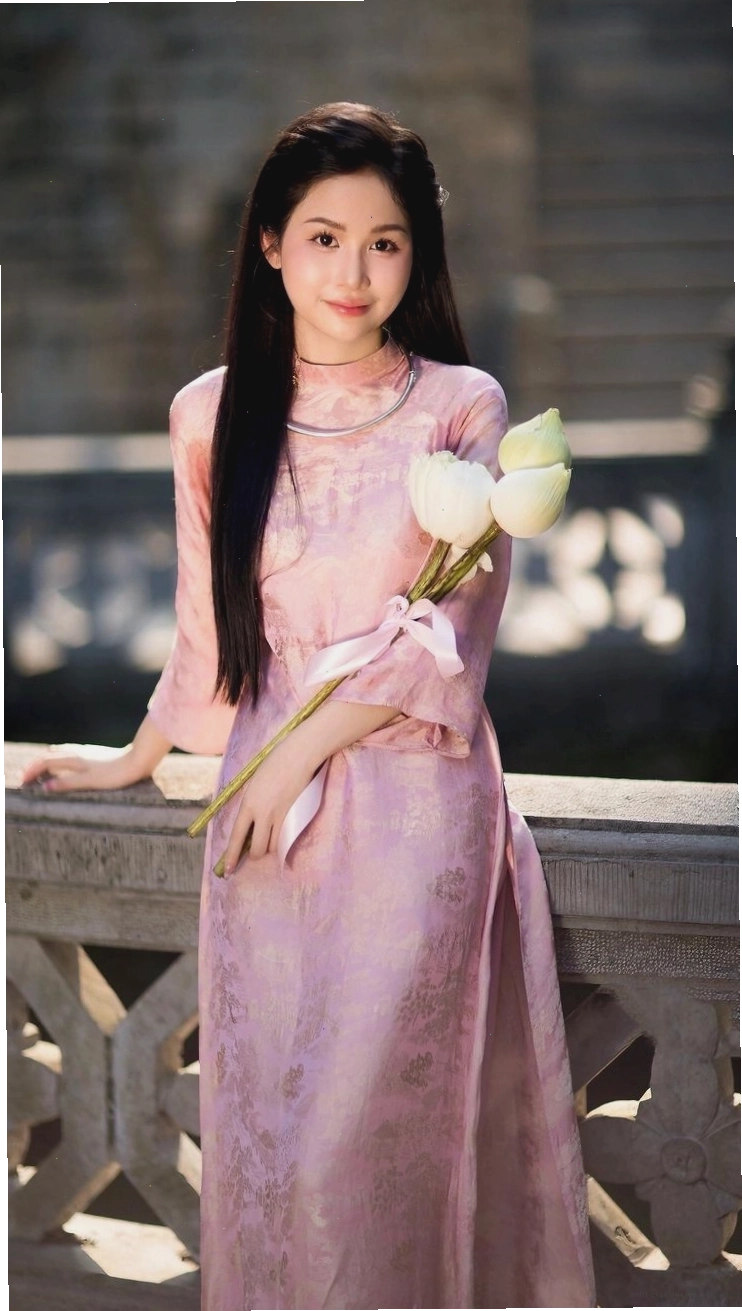 Mẫu áo dài lụa vàng chanh với họa tiết hoa sen, cổ tròn, tay lỡ.