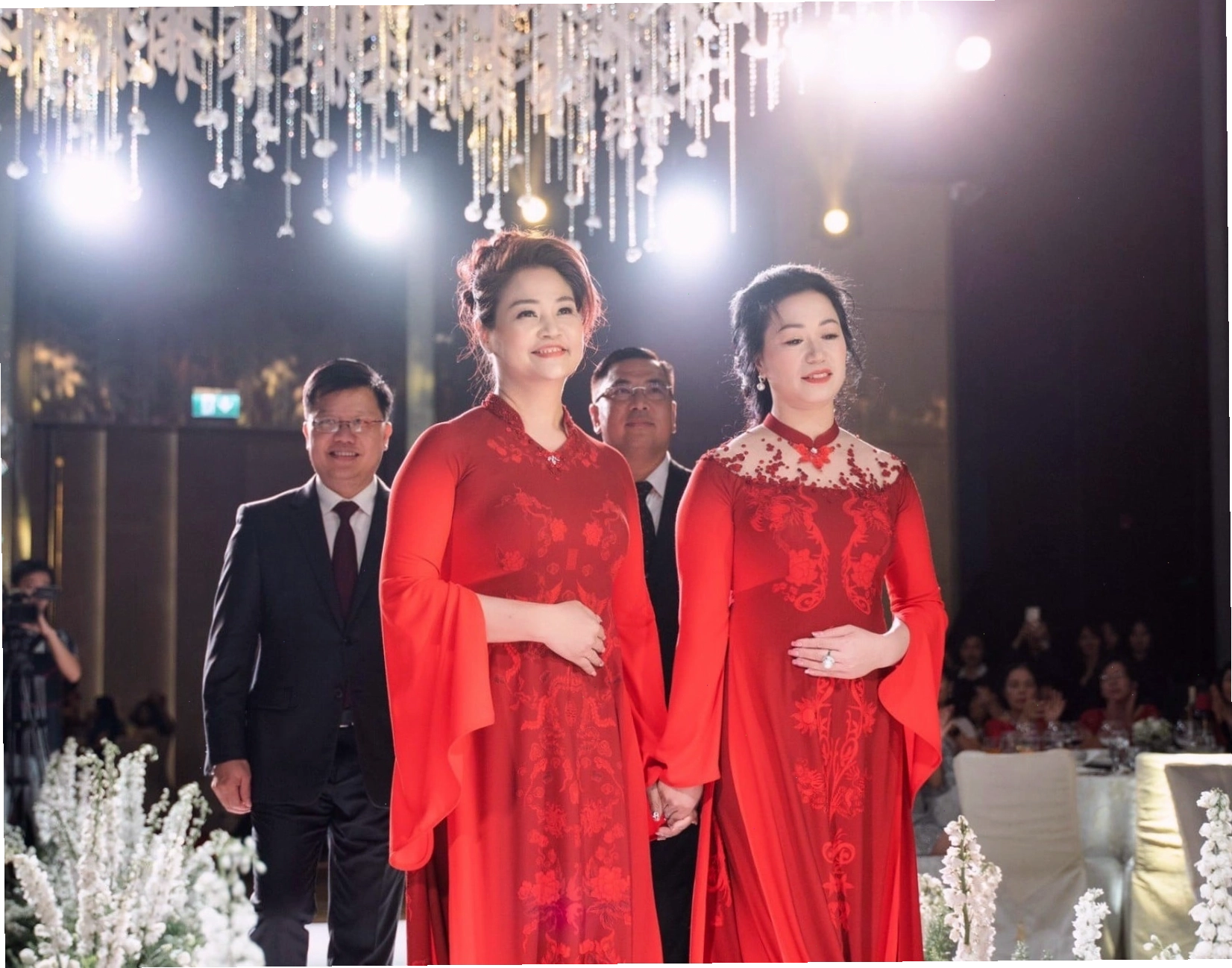 Mẹ cô dâu diện áo dài màu be lụa trơn, cổ tròn đính kết đá sang trọng