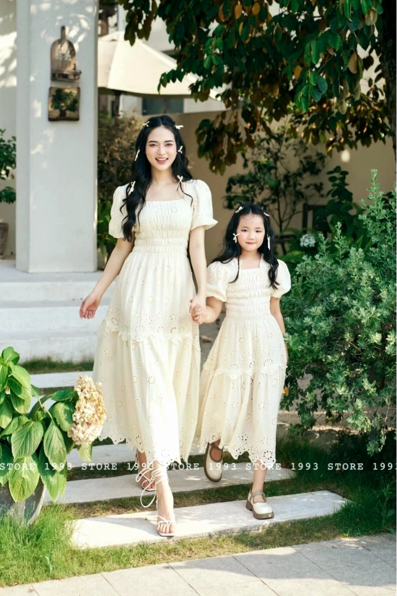 Mẹ và bé cùng diện áo phông trắng và quần jeans, tạo dáng vui đùa