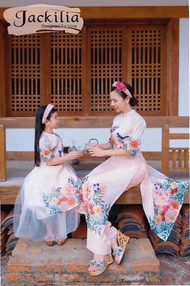 Mẹ và bé gái diện váy đôi màu xanh dương, tạo dáng nhí nhảnh