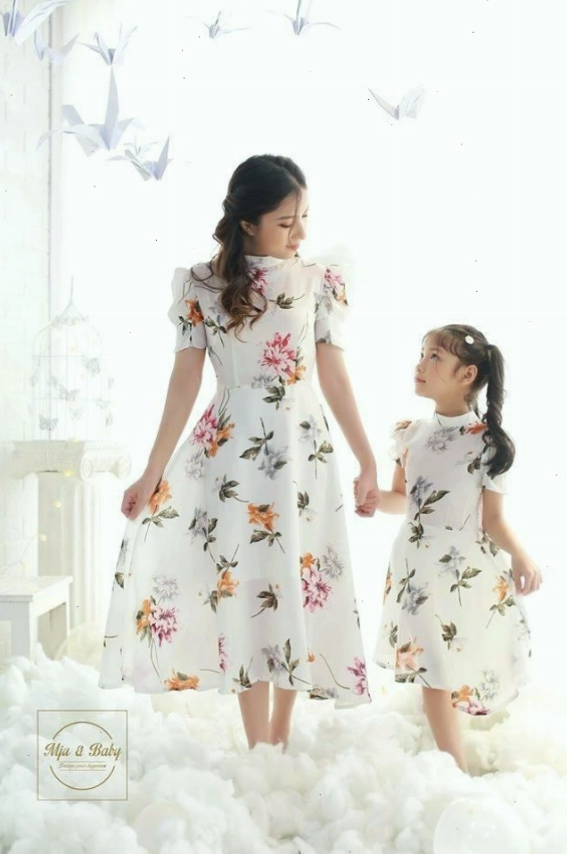 Mẹ và bé gái mặc đồ đôi màu xanh mint, tạo dáng vui đùa