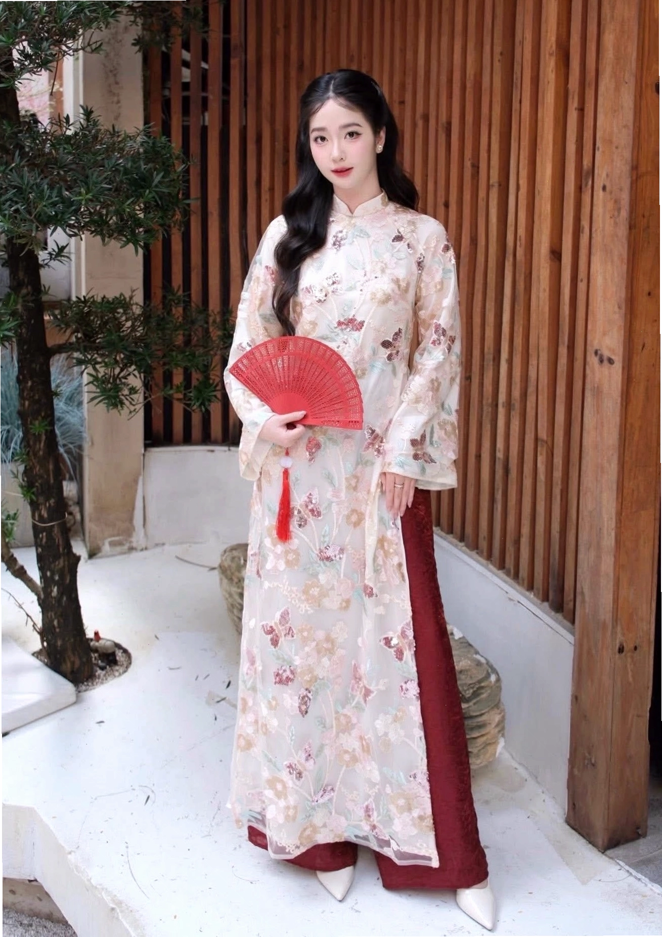 Người mẫu diện áo dài cách tân màu trắng tay lỡ, cổ tròn phối quần ống rộng
