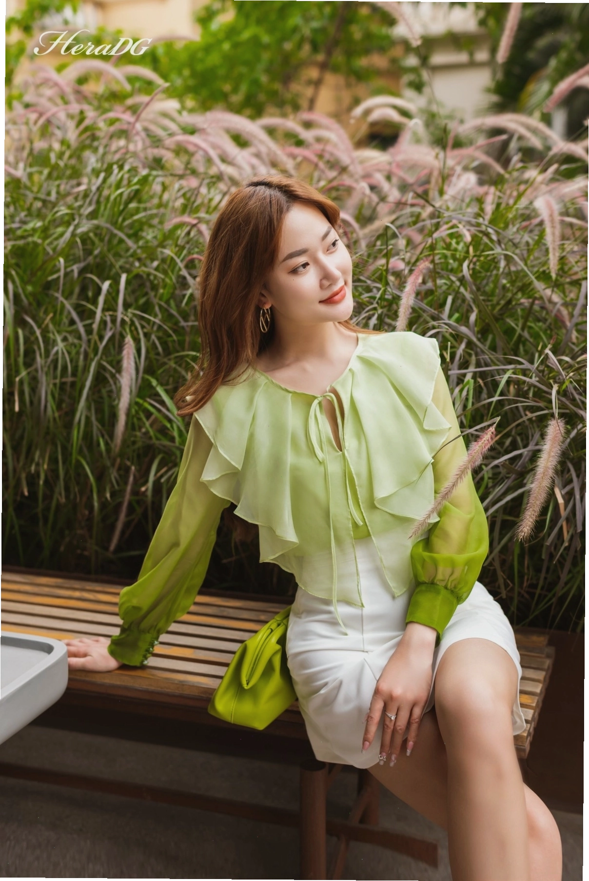 Người mẫu diện áo dài cổ bèo tay lỡ màu hồng pastel, cổ xếp bèo nhún tinh tế, phối cùng quần lụa trắng thanh lịch