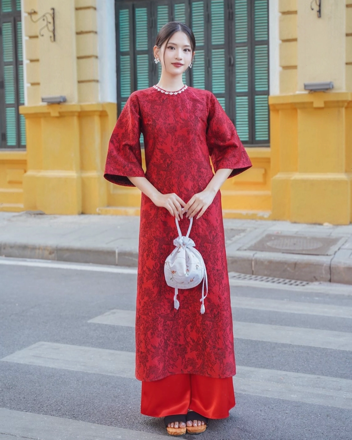 Người mẫu trẻ trung diện áo dài cách tân màu trắng họa tiết hoa nhí, quần lụa đen ống suông
