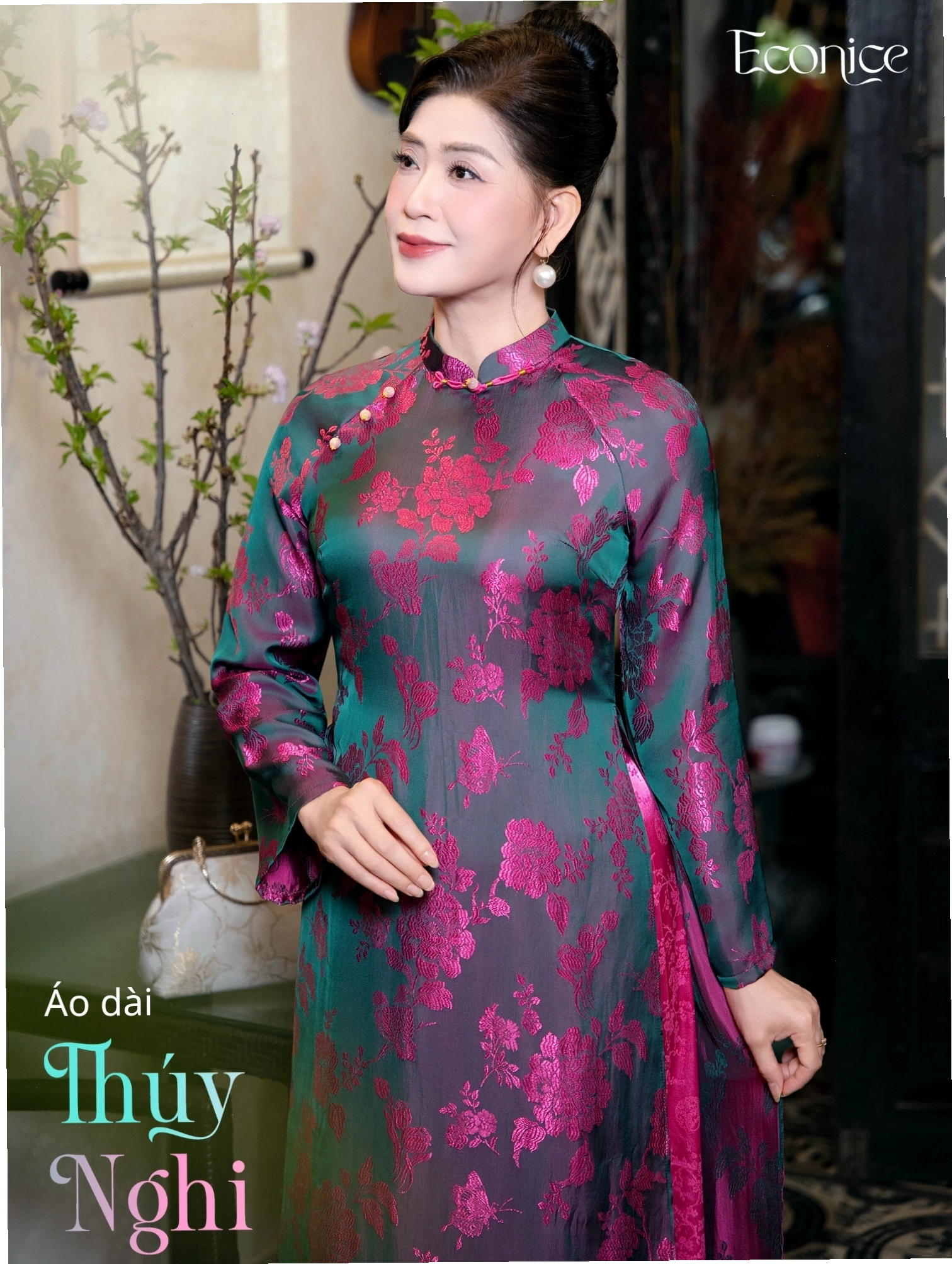 Set áo dài cách tân màu đỏ đô, cổ tròn, tay phồng, phối cùng quần lụa đen và túi xách đen.