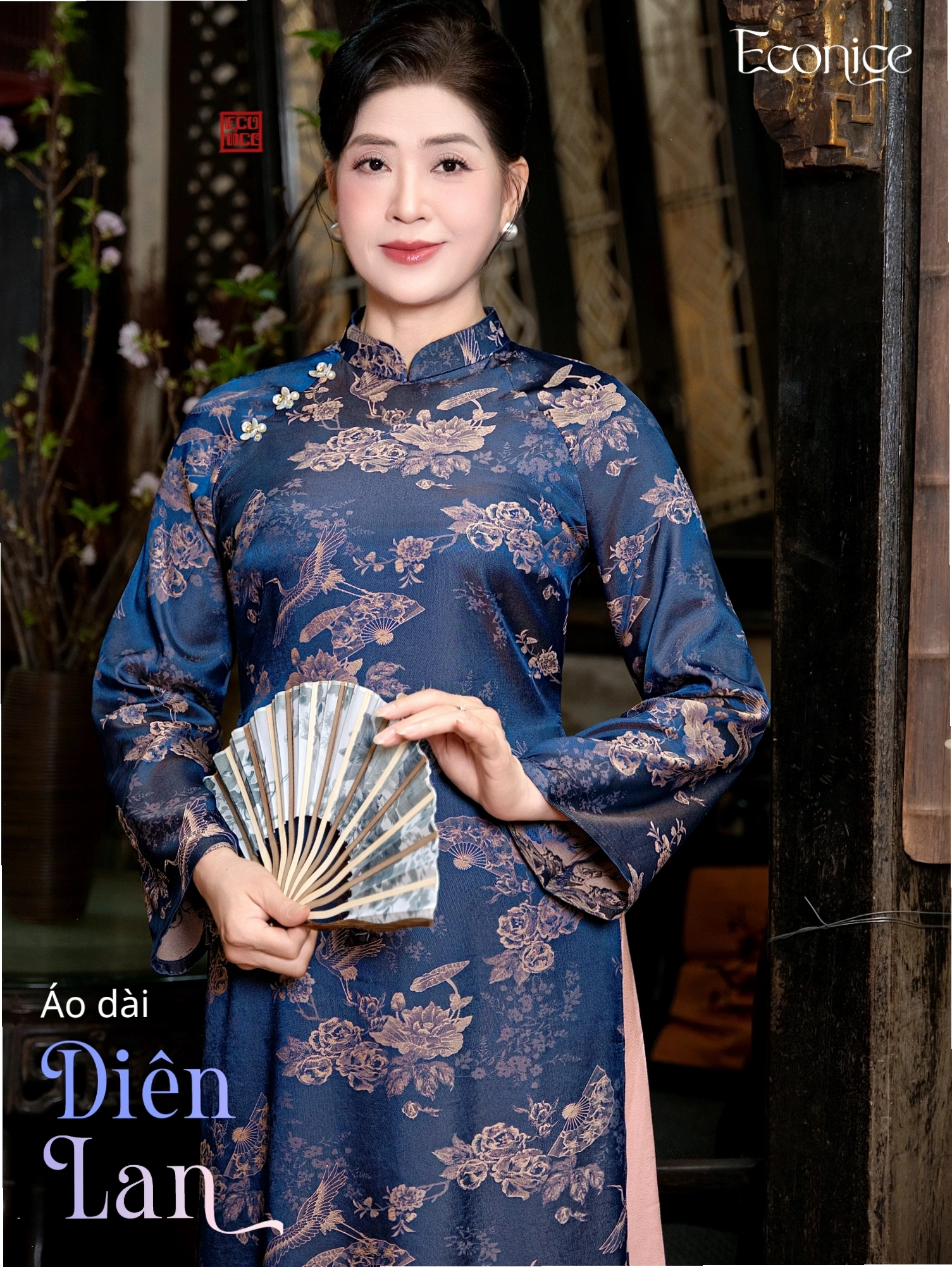 Set áo dài cách tân màu vàng đồng, cổ thuyền, tay lỡ, phối cùng quần lụa trắng.