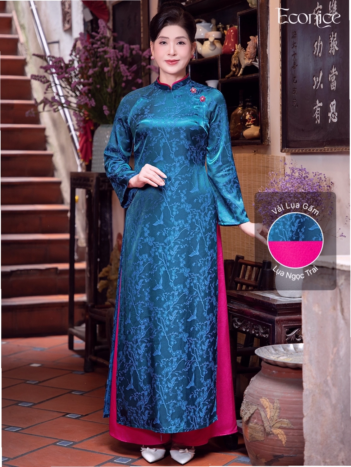 Set áo dài cách tân màu xanh dương đậm, cổ tròn, tay phồng, phối cùng quần lụa trắng.