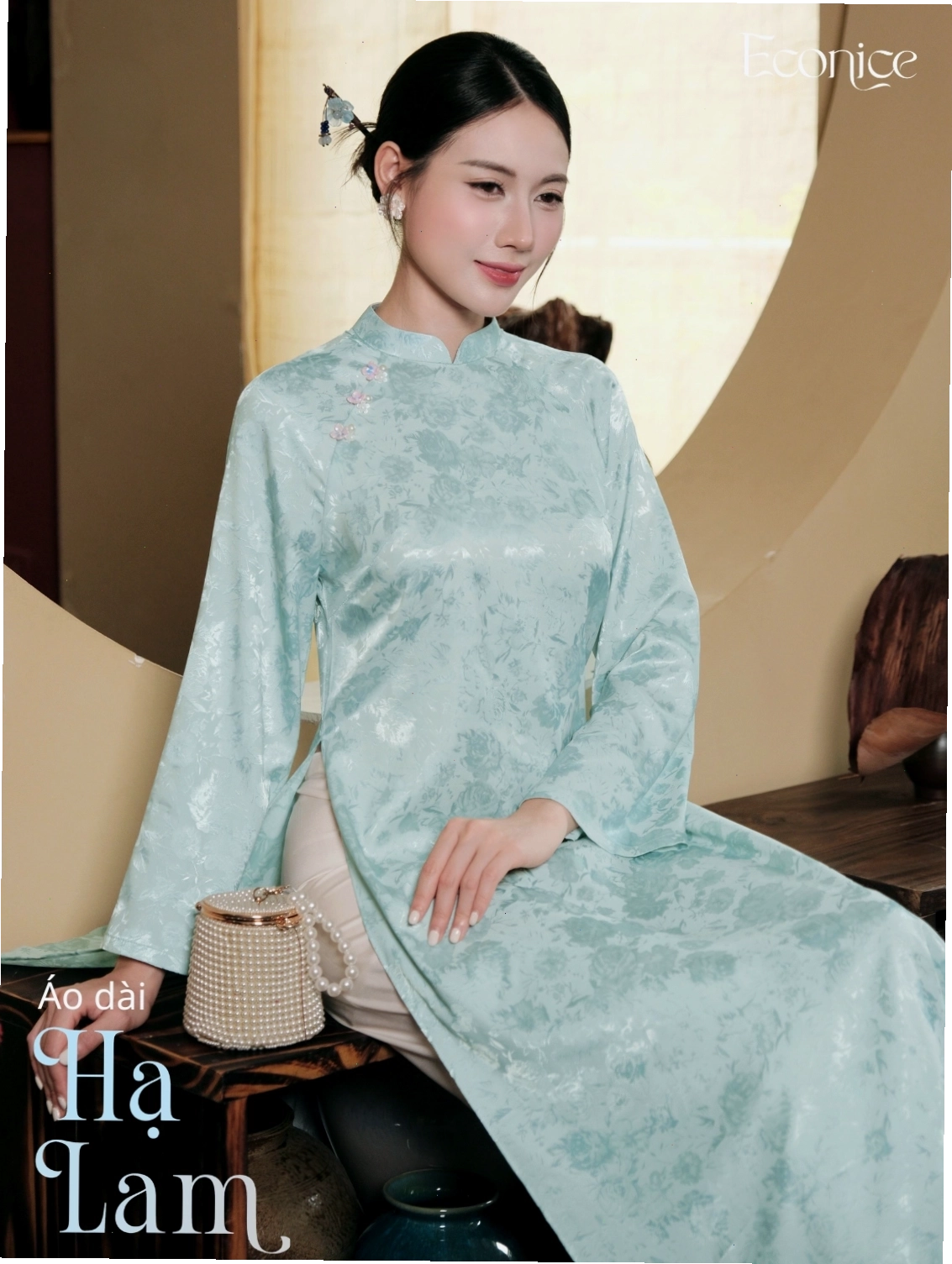 Set áo dài cách tân màu xanh ngọc bích, họa tiết hoa nhí, dáng suông, cổ thuyền, phối cùng quần lụa trắng ống rộng.