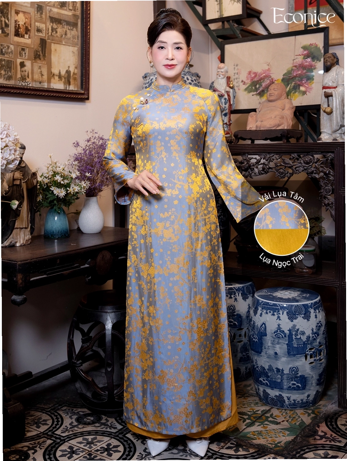 Set áo dài cách tân tay phồng màu hồng fuchsia, cổ tròn, phối cùng quần lụa đen và túi xách mini.