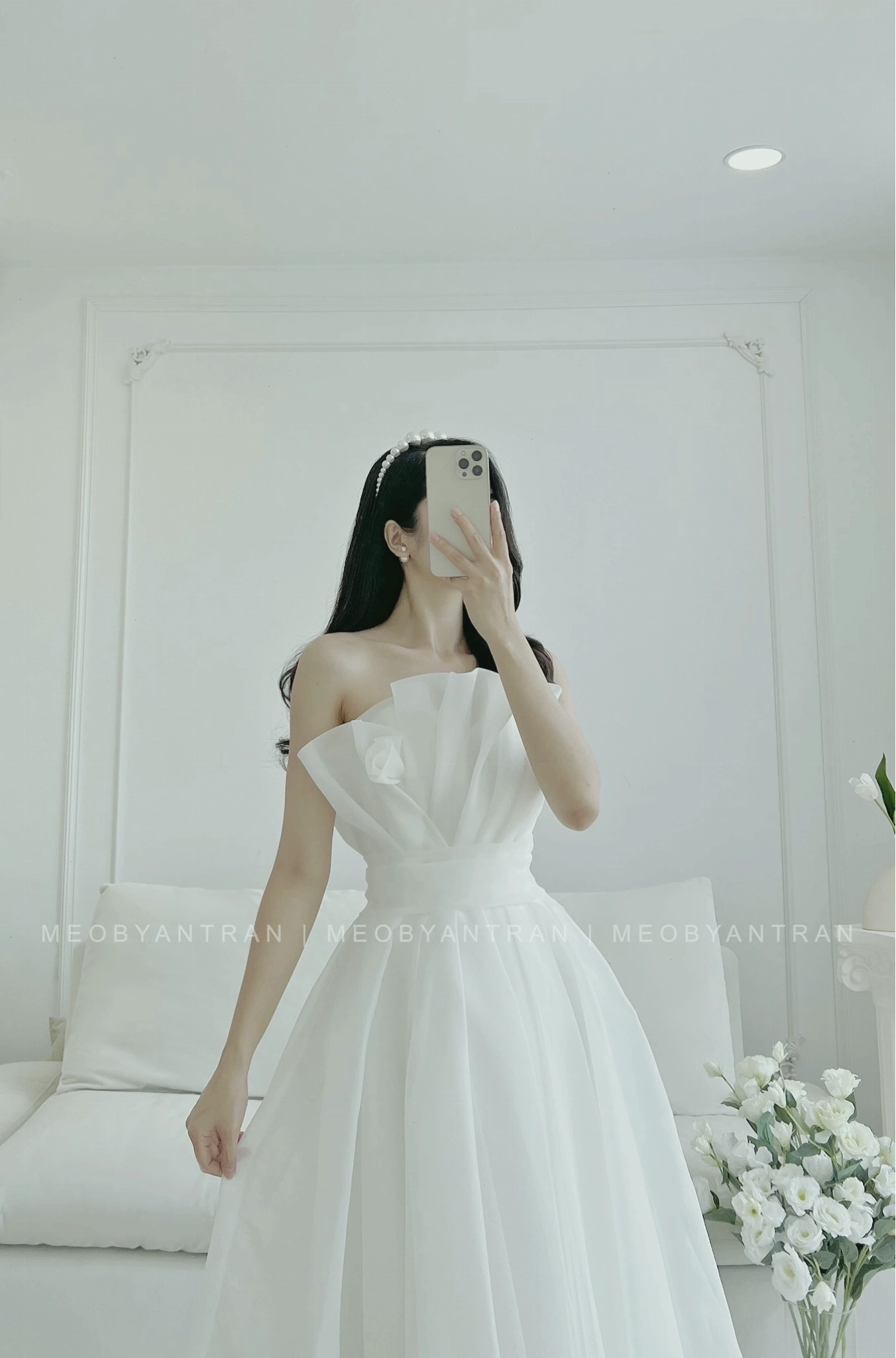 Váy voan dáng midi màu hồng pastel, cổ vuông, tay bồng, chân váy xòe nhẹ, điểm nhấn là những đường viền ren tinh tế